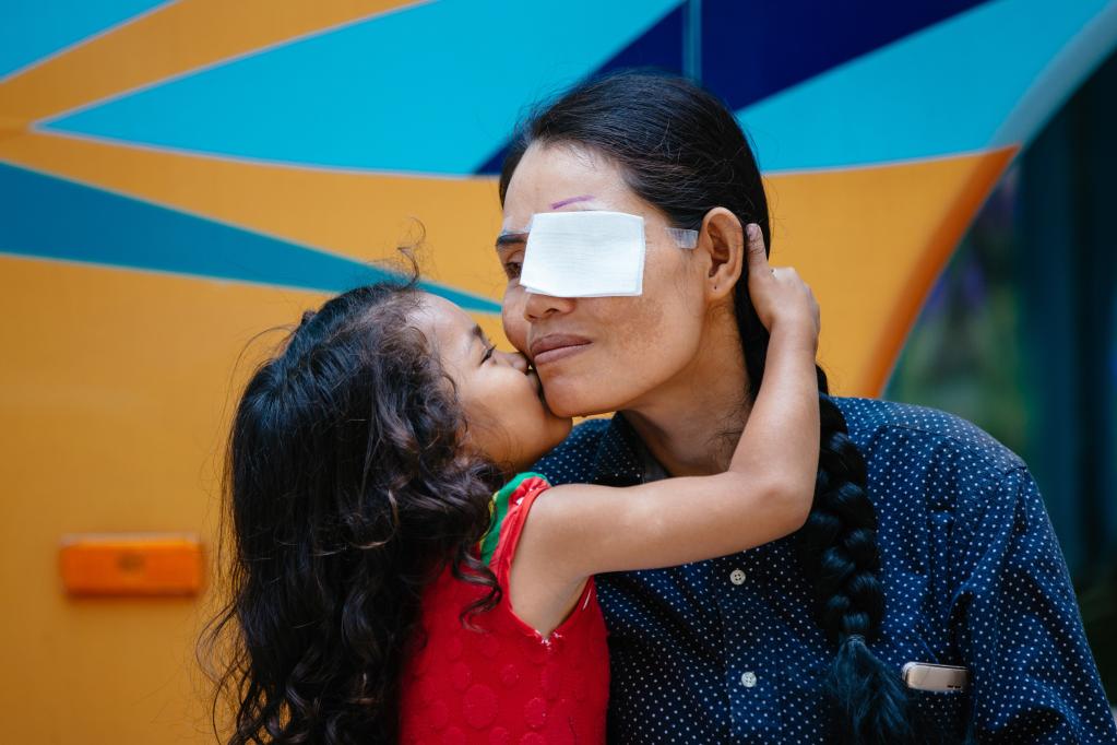 2019年3月15日，在柬埔寨磅湛省医院，即将接受白内障手术的患者孙美乐接受女儿的亲吻祝福。在接受了中国医疗队的白内障义诊手术后，她的视力逐步恢复，生活有了新的光明和希望。
